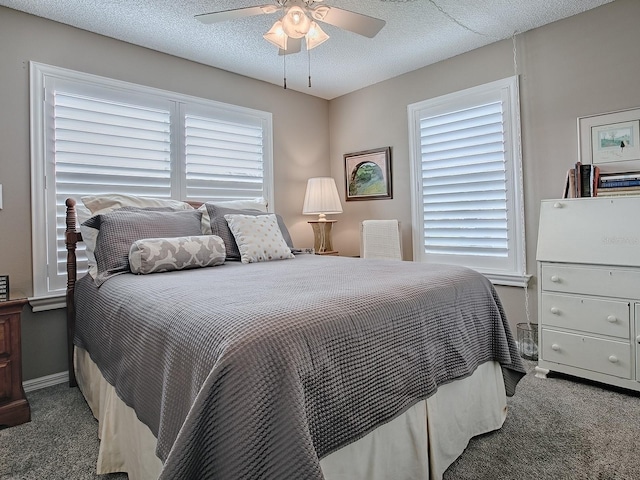 bedroom with a ceiling fan, multiple windows, dark carpet, and a textured ceiling