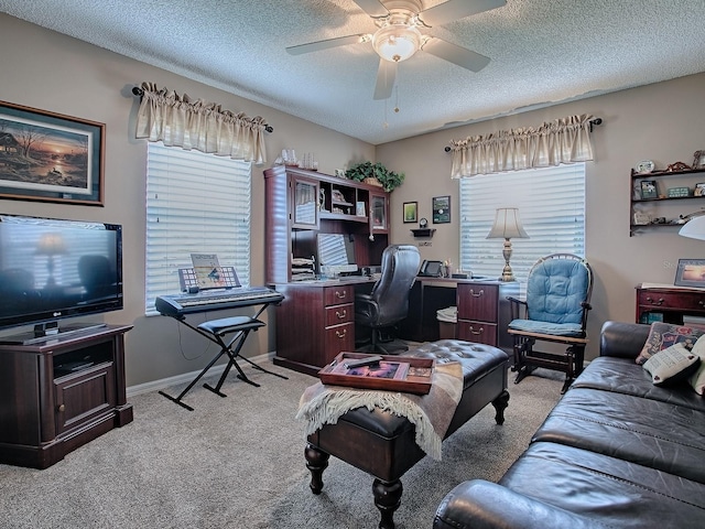 office featuring light colored carpet, ceiling fan, a textured ceiling, and baseboards