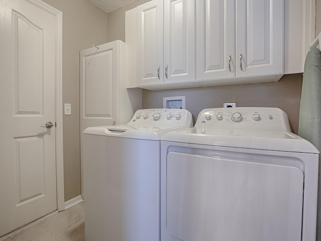 laundry area featuring washing machine and clothes dryer and cabinet space