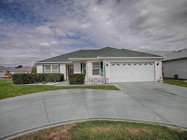 ranch-style house with a garage, driveway, a front lawn, and roof with shingles