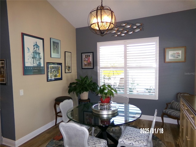 dining room featuring a chandelier, dark wood-type flooring, and lofted ceiling