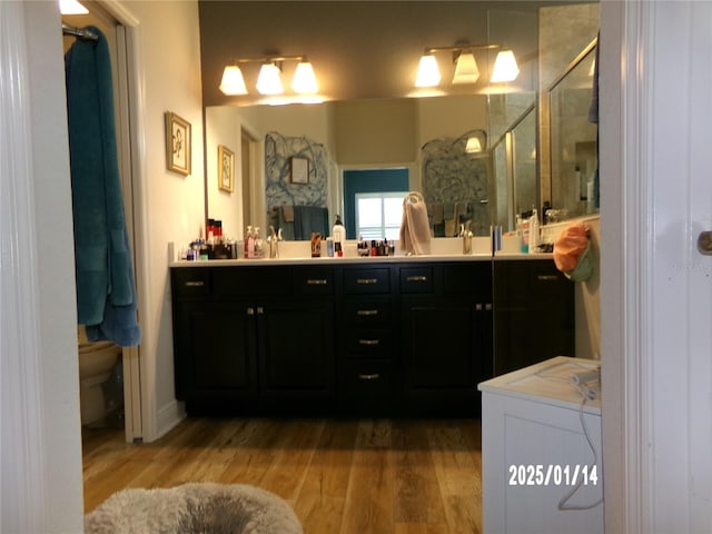 bathroom featuring toilet, hardwood / wood-style flooring, and vanity