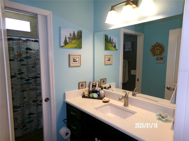 bathroom featuring toilet, vanity, and a shower with curtain