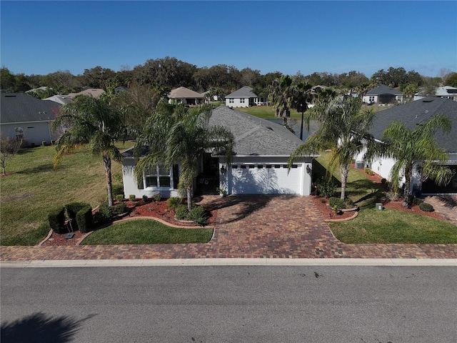 10173 Julia Isles Ave, Oxford, FL 34484 - view of front of house with a residential view, driveway, a front lawn, and an attached garage