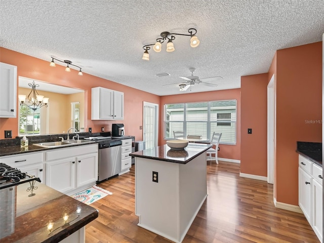 kitchen featuring dark stone countertops, sink, stainless steel dishwasher, and white cabinets