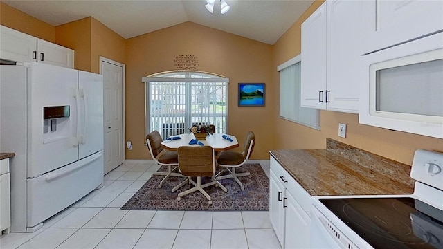 kitchen with white cabinetry, white appliances, lofted ceiling, and light tile patterned flooring