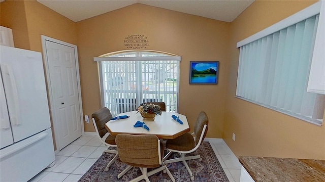 tiled dining room with lofted ceiling