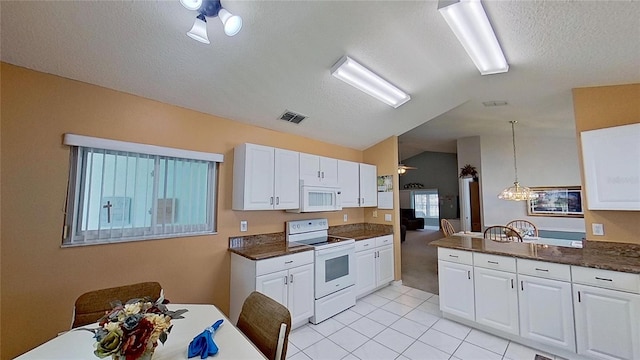 kitchen with lofted ceiling, white appliances, white cabinets, decorative light fixtures, and kitchen peninsula