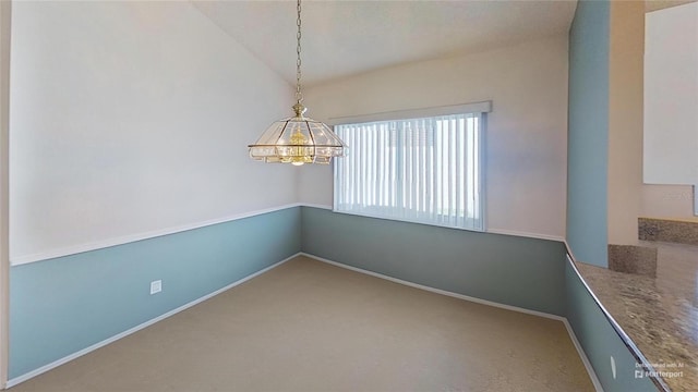 unfurnished dining area with vaulted ceiling and carpet