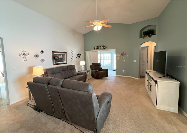 carpeted living room with ceiling fan and high vaulted ceiling