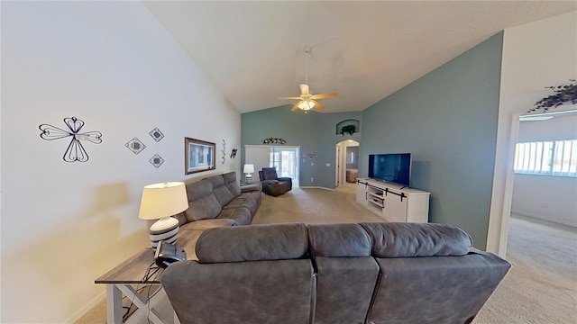 living room with ceiling fan, light colored carpet, and high vaulted ceiling