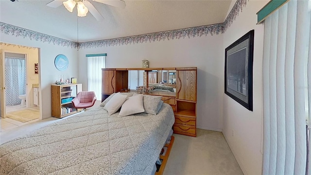 bedroom featuring light carpet, ensuite bath, vaulted ceiling, and ceiling fan