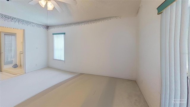 spare room with a textured ceiling and ceiling fan