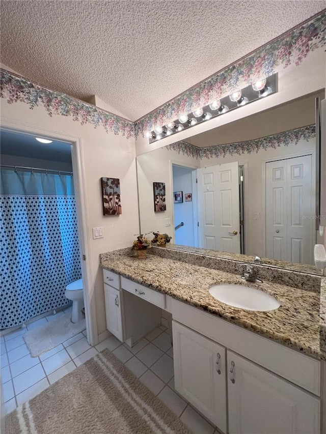 bathroom with tile patterned flooring, vanity, a textured ceiling, and toilet