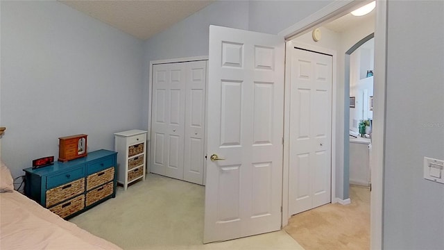 carpeted bedroom featuring vaulted ceiling and a textured ceiling