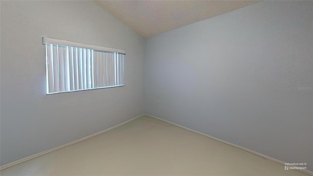 carpeted empty room with vaulted ceiling and a textured ceiling