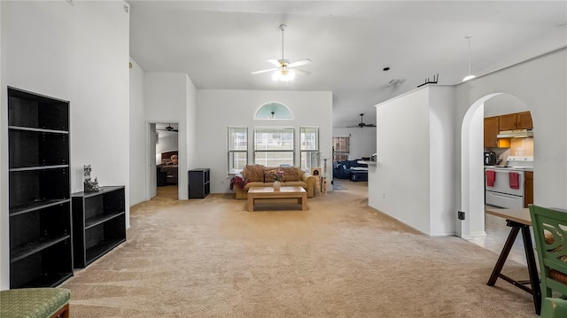 interior space with high vaulted ceiling, light colored carpet, and ceiling fan