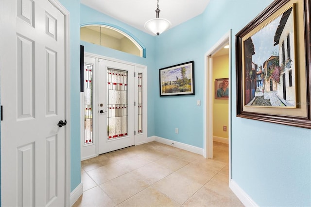 foyer featuring light tile patterned floors, a wealth of natural light, and baseboards