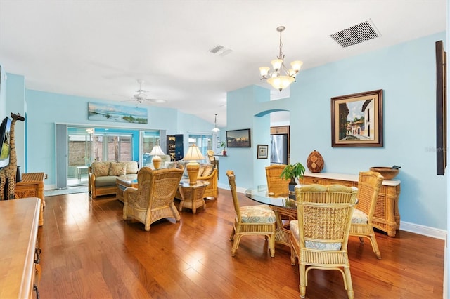 dining space with visible vents, arched walkways, and wood finished floors