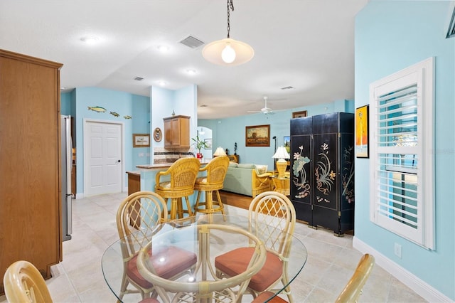 dining space featuring baseboards, ceiling fan, visible vents, and a wealth of natural light