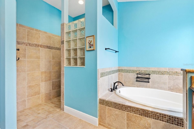 full bathroom with tile patterned flooring, walk in shower, a bath, and vanity