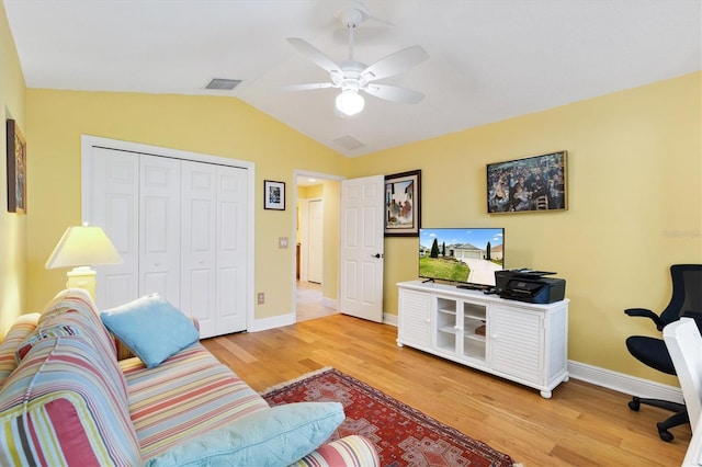 living room featuring lofted ceiling, visible vents, light wood-style flooring, and baseboards