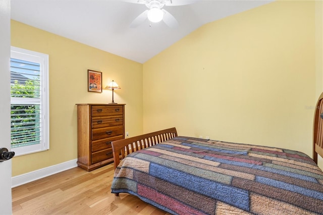 bedroom with lofted ceiling, light wood-style flooring, baseboards, and ceiling fan