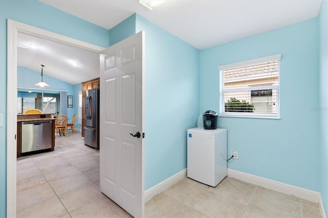 clothes washing area with light tile patterned floors, baseboards, and a wealth of natural light