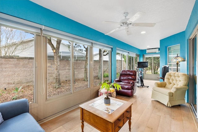 sunroom / solarium featuring a wall mounted air conditioner and a ceiling fan