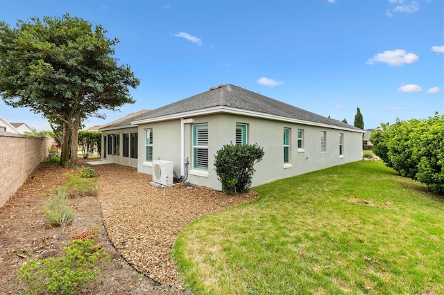 back of property featuring ac unit, a lawn, fence private yard, and stucco siding