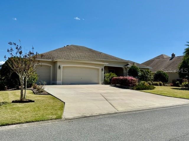 single story home featuring a garage, driveway, a front lawn, and stucco siding