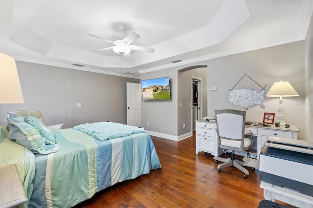 bedroom featuring visible vents, dark wood finished floors, a raised ceiling, baseboards, and arched walkways