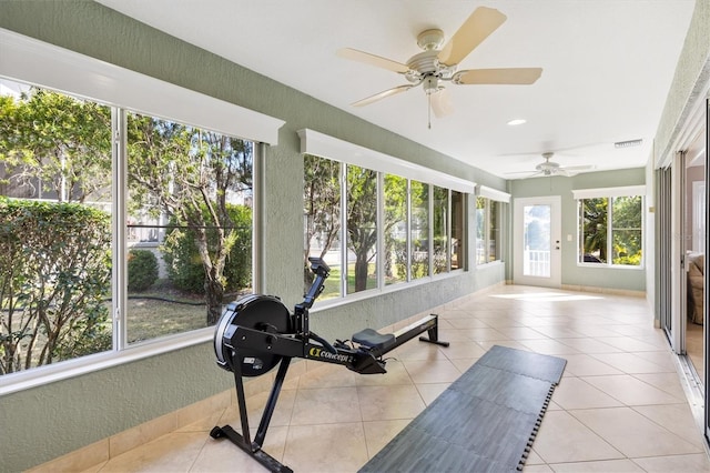 workout room with visible vents, light tile patterned floors, and a textured wall