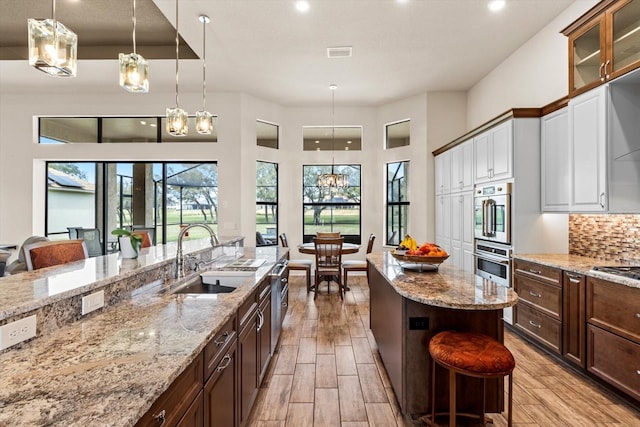 kitchen with sink, backsplash, white cabinets, and a breakfast bar