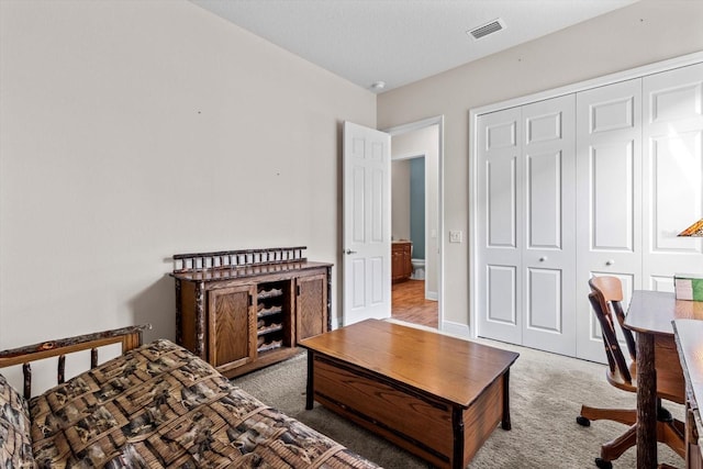 bedroom featuring light carpet and a closet