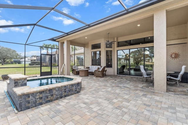 view of patio featuring ceiling fan, an outdoor hot tub, glass enclosure, and outdoor lounge area