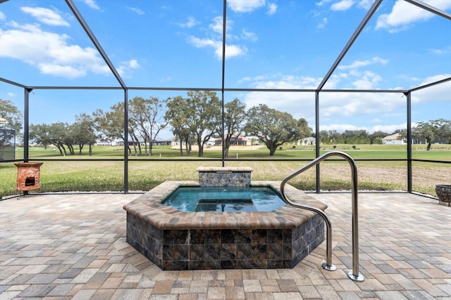 view of patio / terrace featuring an in ground hot tub and glass enclosure