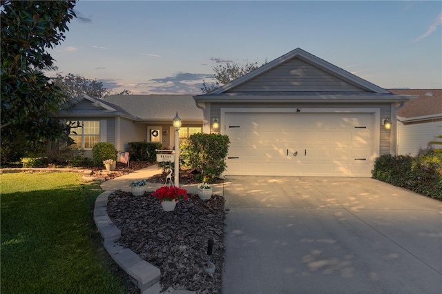 ranch-style home with a garage, concrete driveway, and a front yard