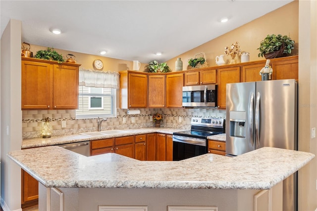 kitchen featuring a center island, lofted ceiling, decorative backsplash, appliances with stainless steel finishes, and a sink