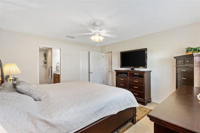 bedroom with ceiling fan, connected bathroom, visible vents, baseboards, and light wood-type flooring