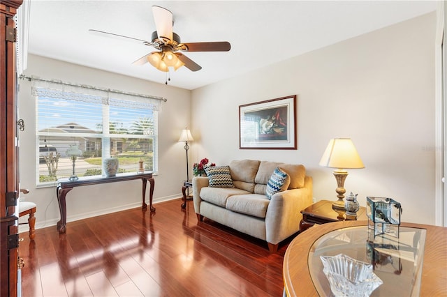 living room with ceiling fan, baseboards, and wood finished floors