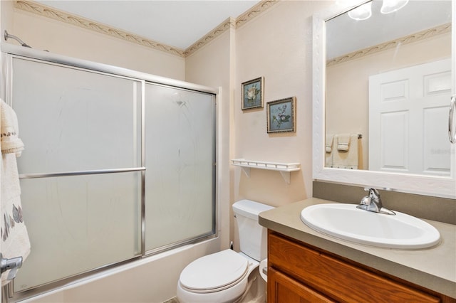 bathroom with enclosed tub / shower combo, vanity, and toilet