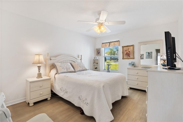 bedroom with baseboards, ceiling fan, and light wood-style floors