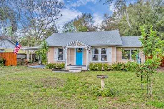 view of front of house featuring a carport, a front yard, and fence