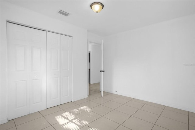 unfurnished bedroom featuring light tile patterned floors and a closet