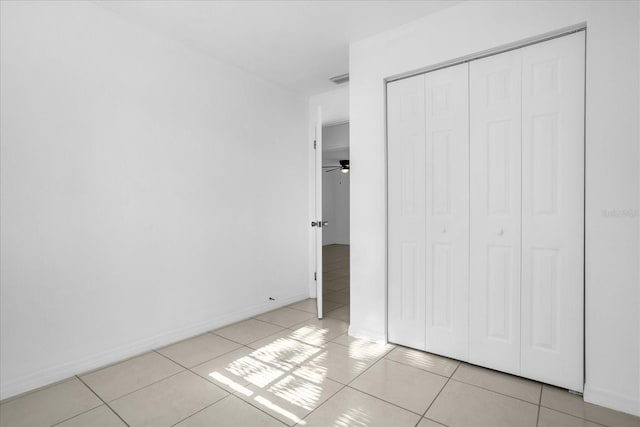 unfurnished bedroom featuring light tile patterned flooring and a closet