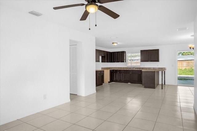 unfurnished living room featuring light tile patterned floors, plenty of natural light, and ceiling fan