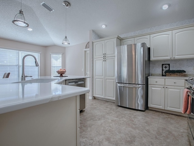 kitchen featuring hanging light fixtures, appliances with stainless steel finishes, sink, and white cabinets