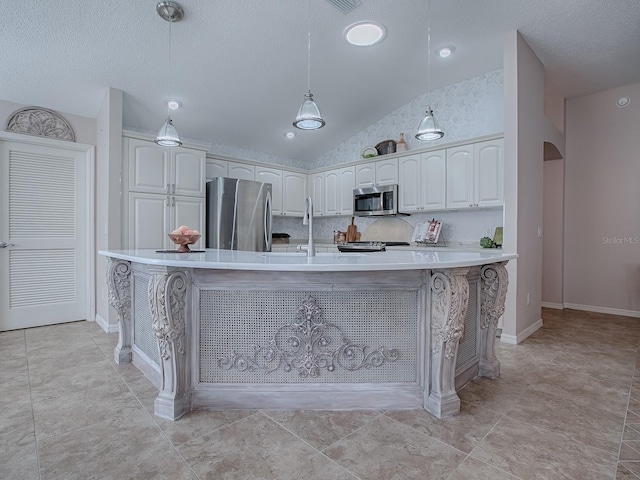 kitchen featuring vaulted ceiling, a center island with sink, pendant lighting, stainless steel appliances, and white cabinets