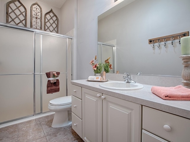 bathroom featuring vanity, a shower with door, and toilet